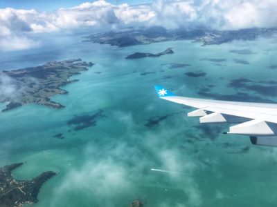 aile d'avion au-dessus d'un océan turquoise et d'îles néo-zélandaises