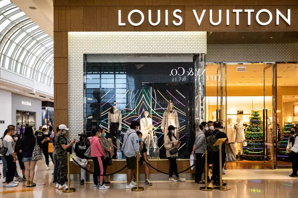 Les clients font la queue devant un magasin Louis Vuitton