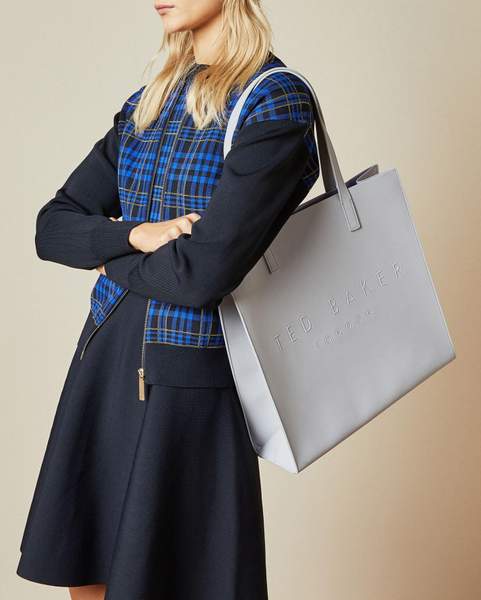 Femme en robe avec un sac à main gris